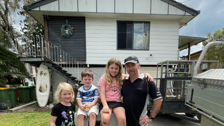 Dirk de Vos and his family out the front of their Goodna property set to be bought back through the Resilient Homes Fund