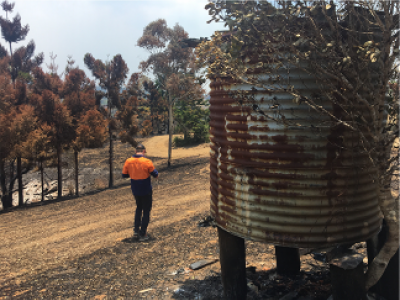 Worker standing near burnt out water tank