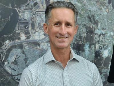 Stuart Smith standing in front of satellite image
