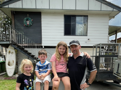 Dirk de Vos and his family out the front of their Goodna property set to be bought back through the Resilient Homes Fund